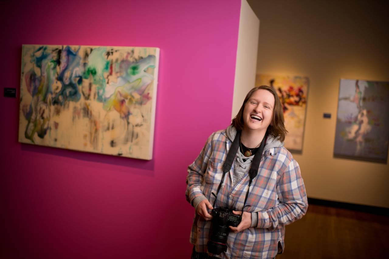 student standing in gallery laughing